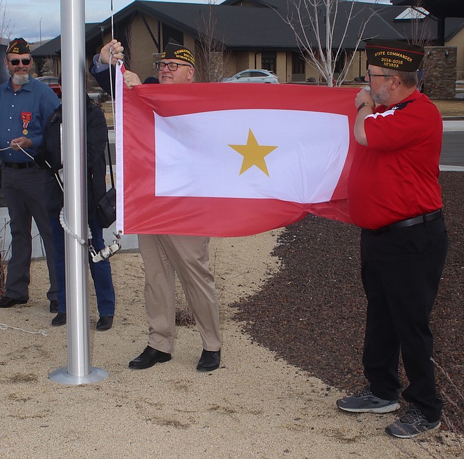 Veterans of Foreign Wars Commander Matthew “Fritz” Milhelcic, left, and David Sousa, committee chairman for the Mid-Winter Nevada Conference, begin to raise a new Gold Star flag at the Gold Star Families Memorial in Sparks. (Photo: Steve Ranson/Nevada News Group)