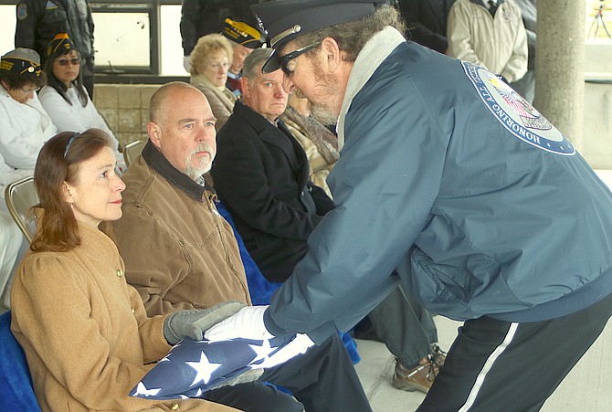 David Rifkin, right, of the Nevada Veterans Coalition, presents a U.S. flag that was draped over John (Jack) Delaney’s casket to his daughter Marion Driscoll during a military service at the Northern Nevada Veterans Memorial Cemetery in Fernley on Monday. Sitting next to Driscoll is her brother, Tim Delaney.