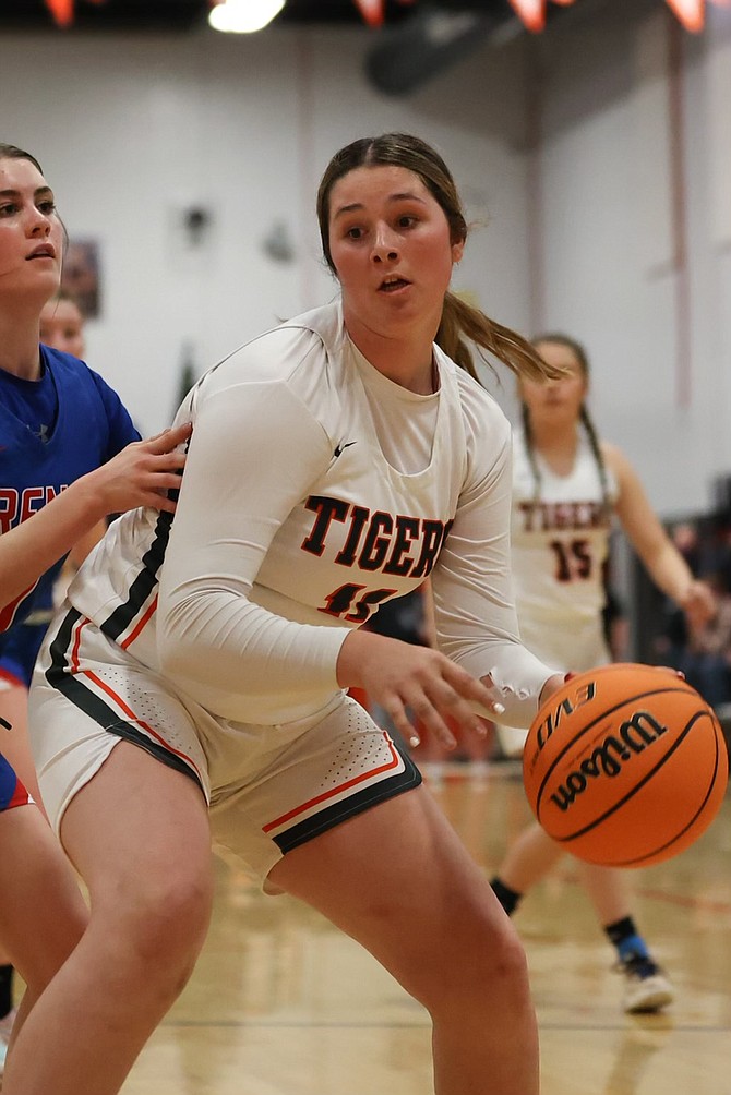 Douglas High's Talia Tretton (11) backs down a Reno defender Tuesday night in the Tigers' loss to the Huskies.
