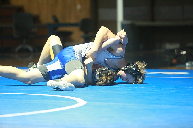 Carson High’s Jeffrey Heaton works his way toward a pin against Douglas’ Connor Jackson at 170 pounds Wednesday, during the Senators’ senior night triangular against the Tigers and Damonte Ranch.