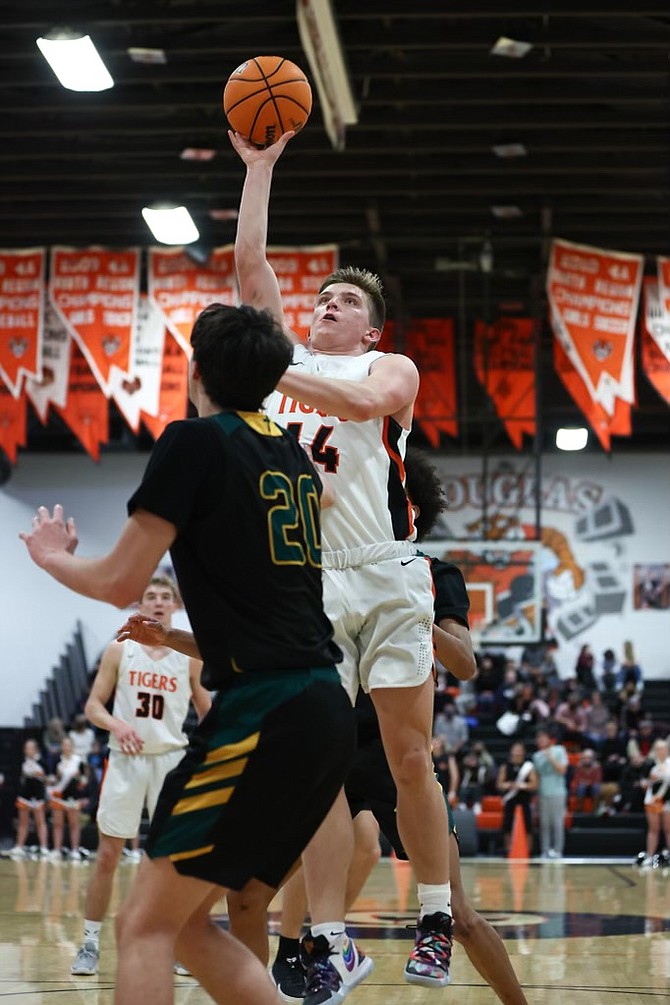 Douglas High's Jac 'JC' Reid lofts up a shot during his 17-point performance Tuesday night against Bishop Manogue. It was the Tigers' first win over the Miners since 2015.