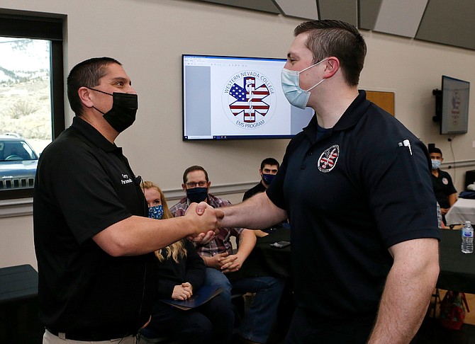 Western Nevada College Emergency Medical Services and Paramedicine Program Coordinator Terry Mendez, left, congratulates Joshua Adams during a graduation ceremony for the first cohort of the paramedic program last year in Carson City.