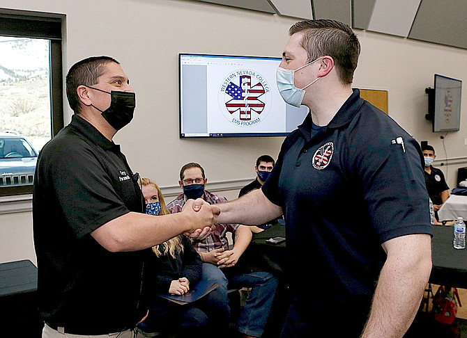 Western Nevada College Emergency Medical Services and Paramedicine Program Coordinator Terry Mendez, left, congratulates Joshua Adams during a graduation ceremony for the first cohort of the paramedic program on Feb. 20, 2021, in Carson City.