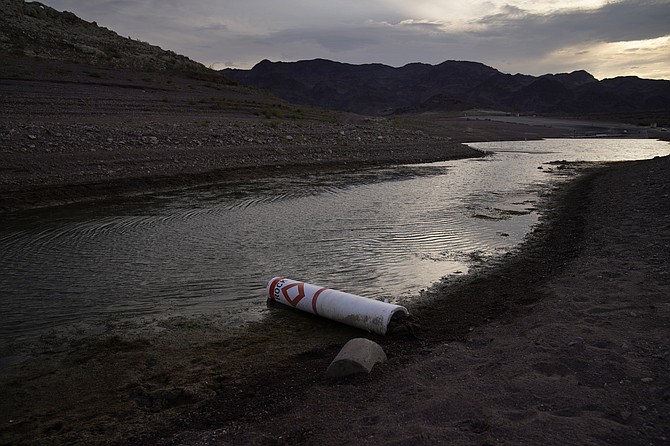 A buoy once used to warn of a submerged rock rests on the ground along the waterline near a closed boat ramp at the Lake Mead National Recreation Area on Aug. 13, 2021, near Boulder City. (Photo: John Locher/AP)