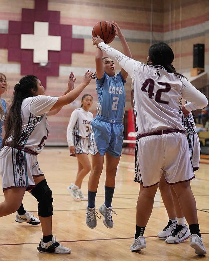 Oasis Academy’s Taylynn Maynez tries to shoot over Pyramid Lake’s defense on Saturday.
