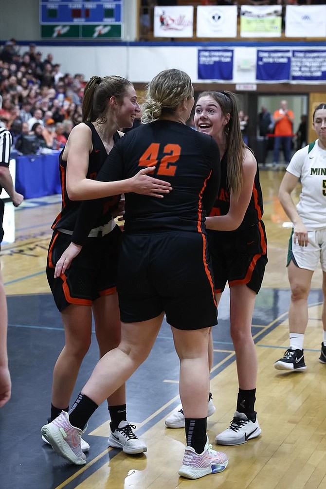 Douglas High's Addy Doerr (14) and Camden Miller (left), celebrate with Riley Mello after a basket during the girls Class 5A North regional final Saturday evening at Carson High.