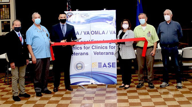 Sergio Espinosa, with scissors, director of outreach with the Nevada Attorney General’s Office of Military Assistance; and Lisa Hamilton, deputy director of the VA Sierra Nevada Health Care System, third from right, participate in a Feb. 11 ceremony to relaunch legal services for veterans and their families.