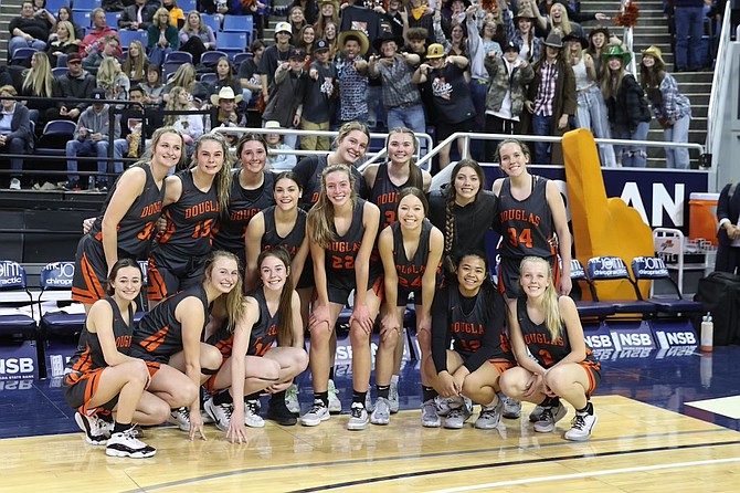 The entire Douglas High girls basketball team poses for a photo in front of the Tiger student section, following their state semifinal appearance against Centennial.