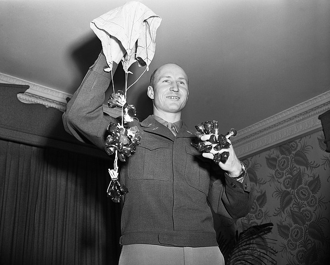 ‘Candy Bomber’ Lt. Gail S. Halvorsen, of Garland, Utah, who started the airlift's ‘Operation Little Vittles’ for candy-starved Berlin children, demonstrates how handkerchief parachutes were used to drop sweets. The 28-year-old lieutenant described the operation of the project at an interview in New York, Jan. 24, 1949. His duties with the Berlin airlift are ended, and he is in the U.S. for reassignment. His work of supplying the Berlin children with candy will be carried on under the supervision of Capt. Lawrence l. Caskey, of Enid, Okla. (AP Photo/Harry Harris)