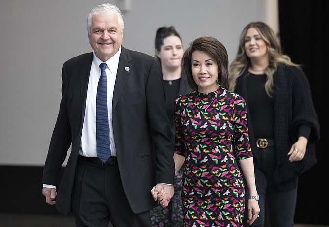 Nevada Gov. Steve Sisolak arrives with his wife Kathy to deliver his State of the State address at Allegiant Stadium in Las Vegas on Feb. 23, 2022. In the background are the governor's daughters Ashley Sisolak, left, and Carley Sisolak. (Steve Marcus/Las Vegas Sun via AP)