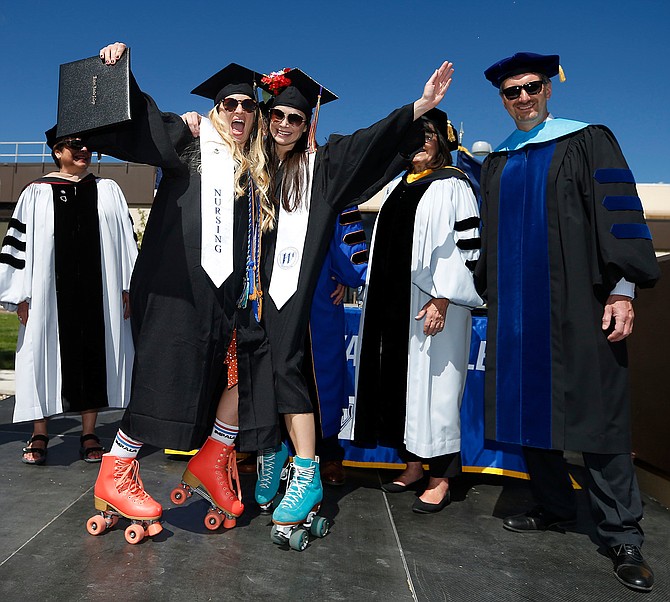 Western Nevada College Interim President Dr. J. Kyle Dalpe, right, celebrates graduates during a 2021 drive-through ceremony at the Carson City campus. WNC will once again hold drive through commencement ceremonies in late May.