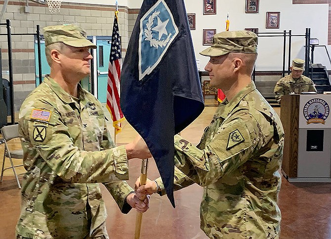 Capt. Adam Gardner, right, receives the JFHQ guidon from Chief of Staff Col. John Krueger in Carson City on March 5, 2022.