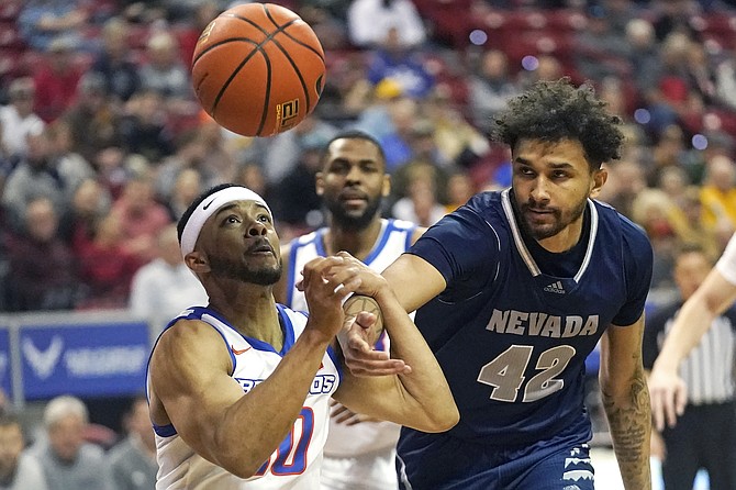 Nevada forward K.J. Hymes (42) and Boise State guard Marcus Shaver Jr. (10) battle for a rebound during the quarterfinals of the Mountain West Conference tournament on March 10, 2022, in Las Vegas.