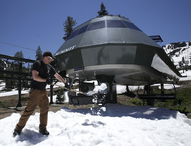 Ozzy Frank shovels snow on to the approach of a ski lift at Alpine Meadows Ski Resort near Tahoe City on June 30, 2011. (AP Photo/Rich Pedroncelli,File)