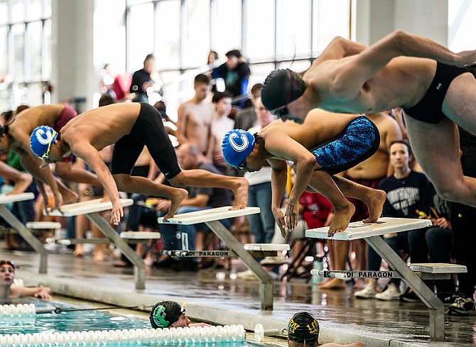 Carson High Arturo Martell-Garcia (left, black jammer) and Vincent Dao leap off the blocks to begin the 100-meter freestyle Saturday morning at the Carson Aquatic Center.