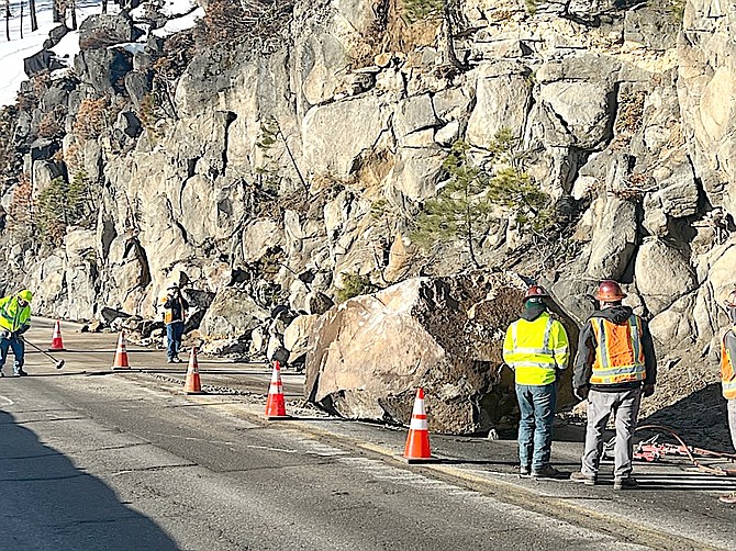 CalTrans workers stand next to a boulder on Echo Summit on Wednesday morning.