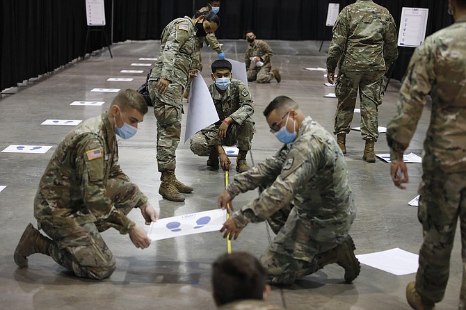Nevada National Guard members install social distancing stickers while setting up a temporary coronavirus testing site in Las Vegas on Aug. 3, 2020.