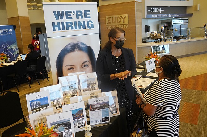 FILE - Marriott human resources recruiter Mariela Cuevas, left, talks to Lisbet Oliveros, during a job fair at Hard Rock Stadium, Friday, Sept. 3, 2021, in Miami Gardens, Fla. Fewer Americans applied for unemployment benefits last week, as layoffs continue to decline amid a strong job market rebound. Jobless claims fell by 15,000 to 214,000 for the week ending March 12, 2022 down from the previous week's 229,000, the Labor Department reported Thursday, March 17.