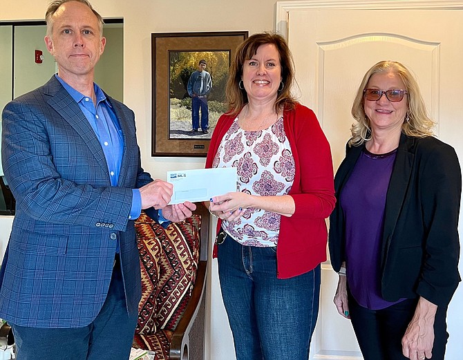NNRMLS CEO George Pickard, left, and NNRMLS President Debbie Logan  with Austin’s House Executive Director Marla Morris (center) accepting a charitable donation.