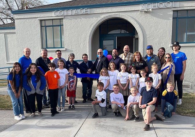 From left City of Fallon Chief of Staff Bob Erickson, Councilman James Richardson, County Commissioner Greg Koenig, city councilwoman Kelly Frost and commissioners Justin Heath and Pete Olsen, and Parks and Recreation Director Jorge Guerrero prepare to cut the ribbon for the new CARES after-school program and the renovation of one building at the Cottage Schools.