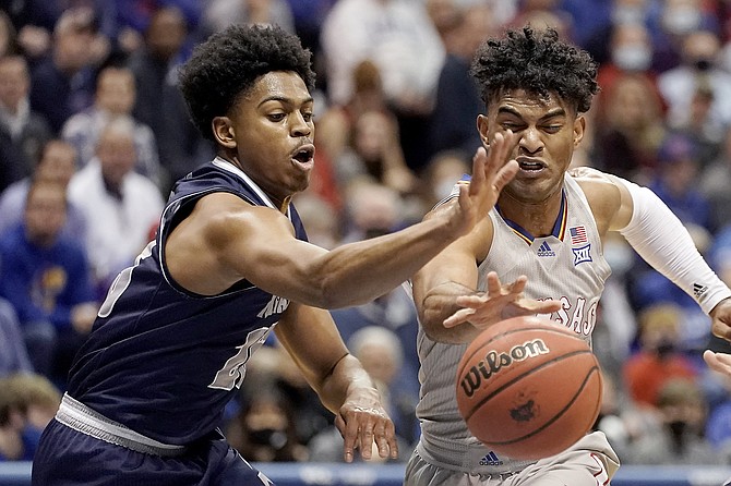 Nevada guard Grant Sherfield, left, and Kansas' Remy Martin chase a loose ball during their game Dec. 29, 2021, in Lawrence, Kan.