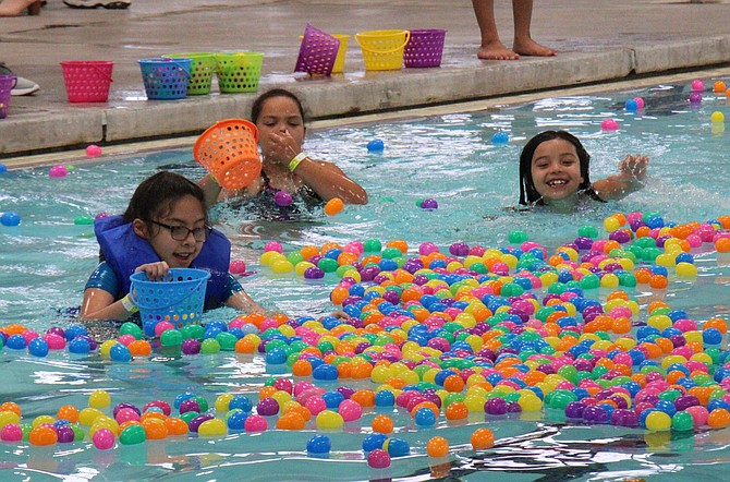 Children scoop baskets-full of eggs out of the Aquatic Facility’s “Big Pool” on Saturday.