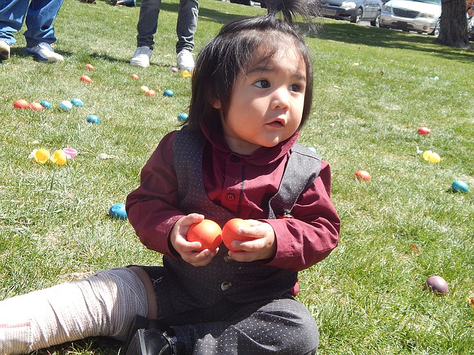One-year-old Conrad Lundy examines his find at Lampe park during the 20-30s Club Easter egg hunt Sunday.