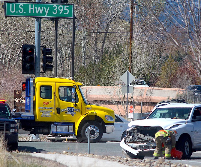 An East Fork firefighter renders a Dodge pickup involved in a collision safe around 10:40 a.m. Saturday at Riverview and Highway 395. An earlier accident on the highway near Airport Road resulted in a death.