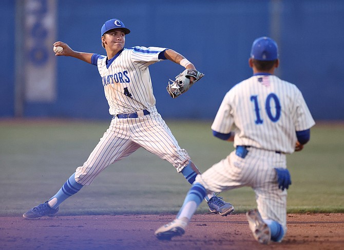 Dillon Damico (4) turns to throw out a Damonte Ranch runner at first base, during Carson's home contest Tuesday evening.