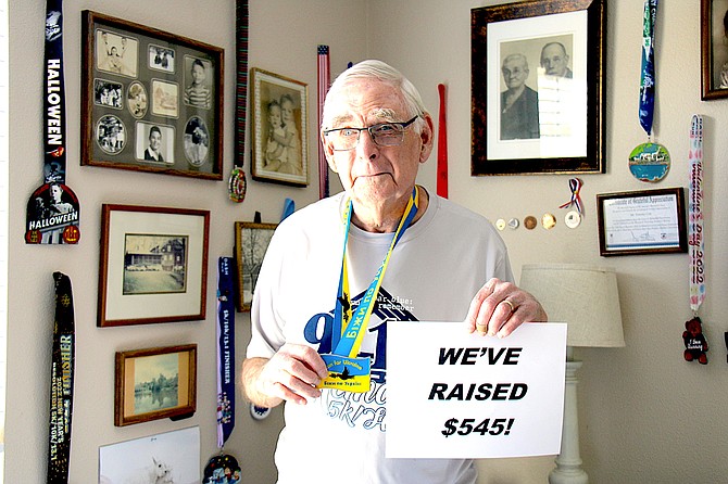 Tim Cole, an 83-year-old Gardnerville resident, stands next to the participation medals he’s collected from walking virtual 5k races. He’s raised over $500 for Ukrainian refugees fleeing Russian invasion.