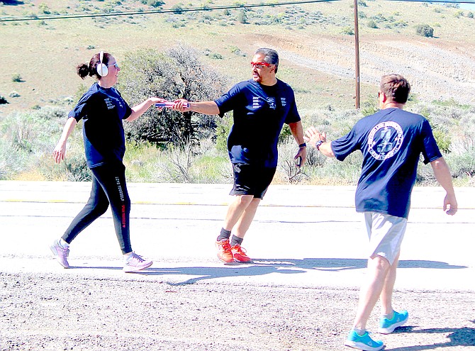 Participants in the Peace Officers Memorial Run conduct a hand-off in Bodie Flat along Highway 395 this morning as the baton continues north.