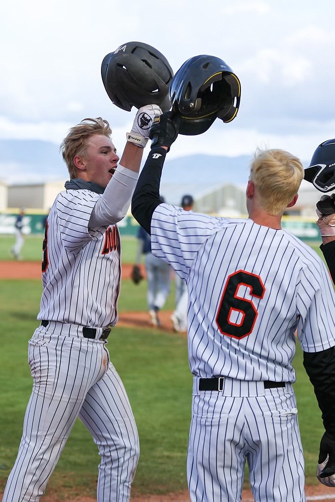 Douglas High's Carson Hill, left, helmet taps Carter Bleeker (6) after Hill belted a three-run homer to left-center field Tuesday for the Tigers.