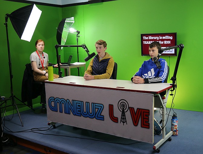 CMNewz Live, Carson Middle School’s student-run newscast, broadcasts daily with news and weather updates. Anchors Sean Thornton, center, and Drew Olson, eighth graders, produce a broadcast on May 9 as Elliot Ruffner, eighth grader, monitors the livestream.