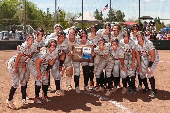 The Douglas High softball team poses with the Class 5A North regional championship plaque after defeating Spanish Springs, 7-6, Saturday at Bishop Manogue High School.