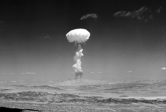 A pillar of smoke with the familiar mushroom top climbs above Yucca Flat during nuclear test detonation on April 22, 1952.