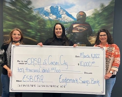 Rebecca Jackson and Nelia Anisio of Eaglemark Savings Bank present a donation of $10,000 to Melanie McCormick (center), executive director of CASA of Carson City. The donation will pay for youth in the foster care system to participate in childhood activities.