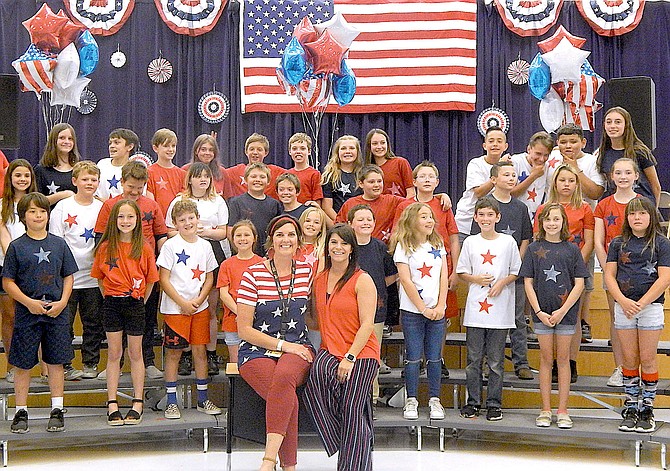 Minden Elementary fifth-grade teachers Amy Carter and Tracey Hall with their fifth-graders during a patriotic program on Thursday.