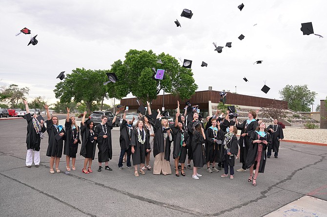 The Oasis Academy Class of 2022 celebrates by throwing their caps in the air after Thursday’s graduation ceremony.