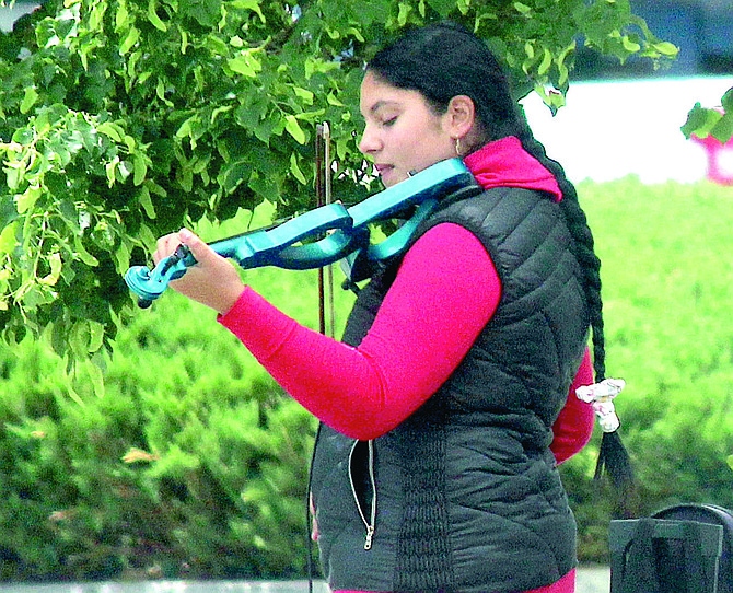A violinist busks in Gardnerville on Saturday.