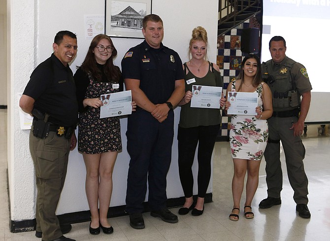 Holiday with a Hero board members honored inaugural scholarship recipients at the recent Salute to Scholars event at Carson High School. Seniors Danielle Van Dusen and Hailee Olson each received $500 for the Hero award and Jennifer Acosta received $1,000 for the Superhero award.