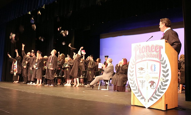 Pioneer Academy’s Class of 2022 graduates toss their caps Wednesday night in the Carson City Community Center theater.