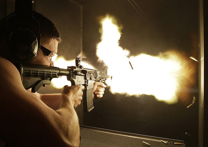 A fully automatic machine gun is fired at a shop in Las Vegas. Nevada will divest from companies that profit from the manufacture or sale of assault-style weapons, state treasurer Zach Conine announced Thursday, June 2, 2022, adding the western state to the list of those that have exempted firearm businesses from their portfolios in recent years. (AP Photo/John Locher, File)