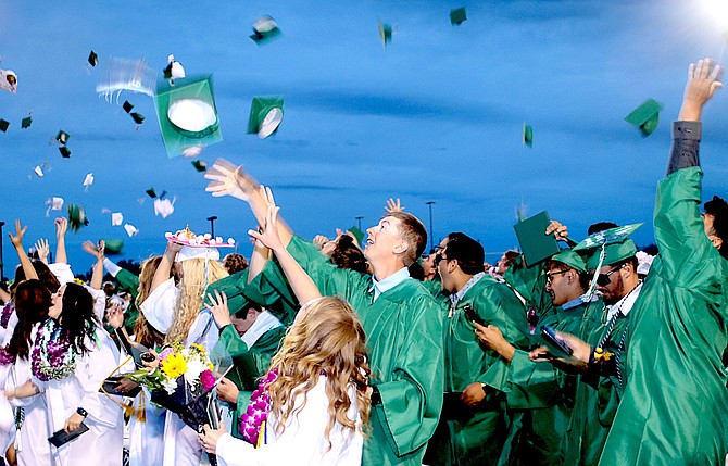 Seniors throw their caps or mortarboards in the air at the end of graduation.