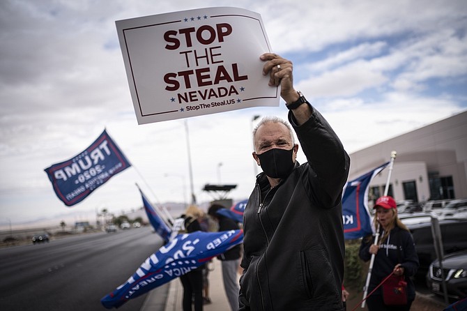 Supporters of President Donald Trump hold signs as they stand outside of the Clark County Elections Department in North Las Vegas on Nov. 7, 2020.