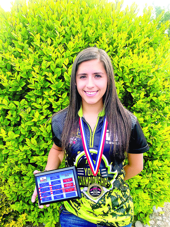 Jenessa Hernandez poses with her plaque that shows her achieve-ments from the 2021-2022 season.