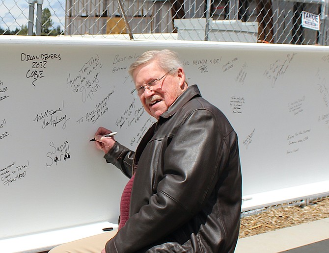 County Commissioner Wes Rice signs his name to a beam going into place in the Stateline Events Center.
