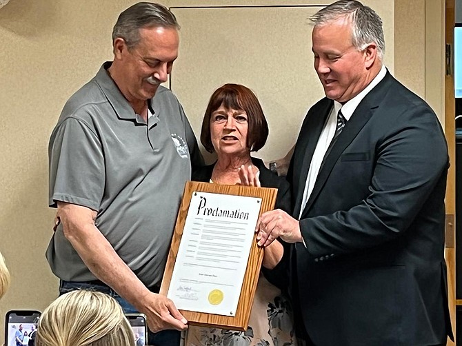 Fallon Mayor Ken Tedford, left, and District Court Judge Thomas Stockard, right, hold a proclamation with Sue Sevon, who recently retired.