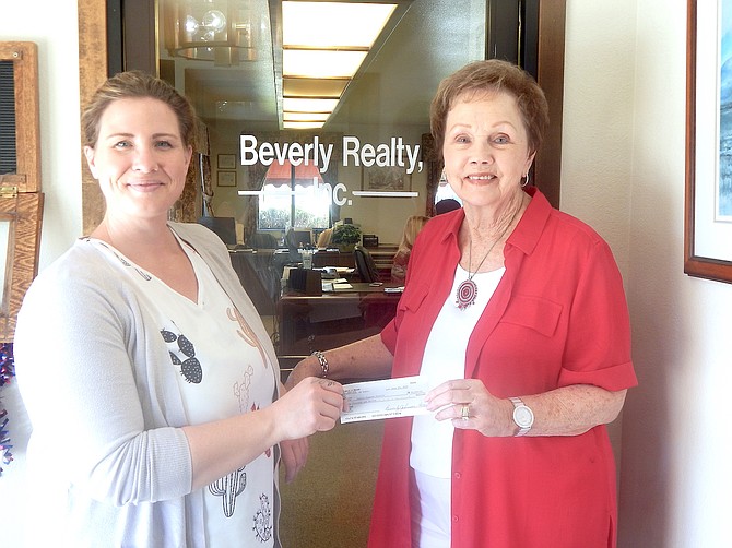 Family Support Council Executive Director Veronica LaChance accepts a $40,000 check donated to the nonprofit by Beverly Johnson, owner of Beverly Reality.