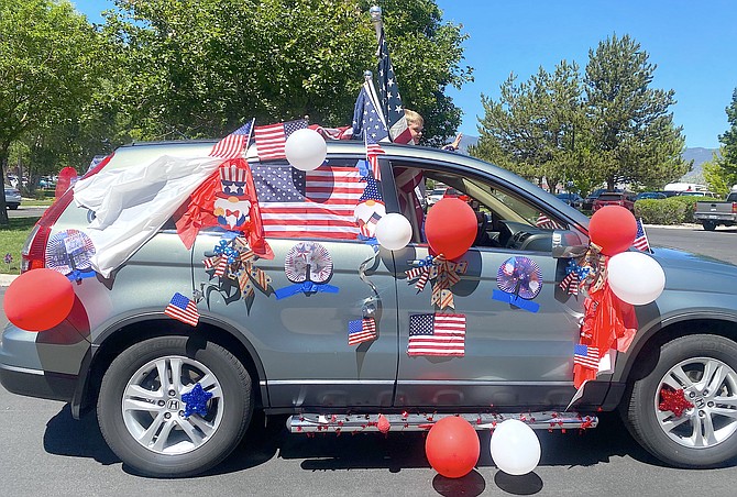 A vehicle decorated in patriotic colors participates in the mini-Fourth of July parade at the Chateau in Gardnerville.