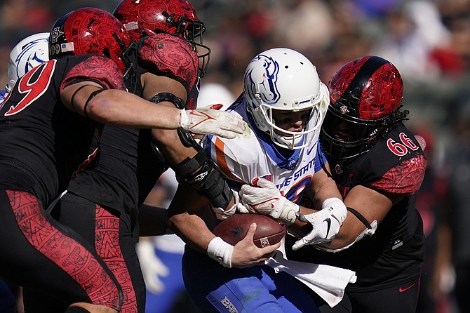 San Diego State defensive lineman Cameron Thomas, left, defensive lineman Keshawn Banks, second from left, and defensive lineman Jonah Tavai (66) sack Boise State quarterback Hank Bachmeier during a game in Carson, Calif., on Nov. 26, 2021.